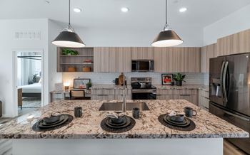 A kitchen with a granite countertop and stainless steel appliances.at Marketside Villas at Verrado, Arizona, 85396